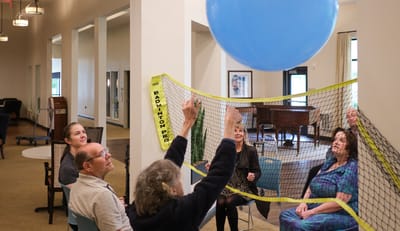 Residents engaged in a volleyball game indoors