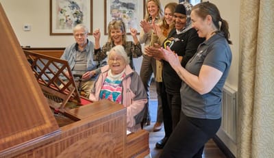 Residents and staff celebrating with music in a common area