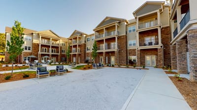 Exterior view of a senior living building with outdoor seating
