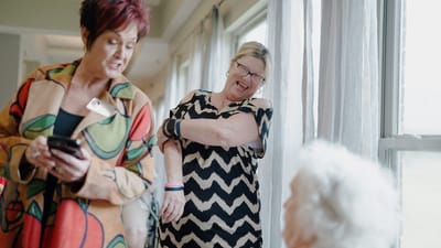 Residents and staff interacting in a bright lounge area