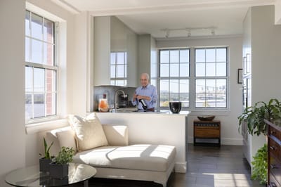 A resident preparing a meal in a bright kitchen area