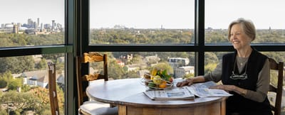 Resident enjoying a view with a newspaper at a table
