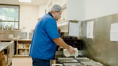 Staff member preparing food in a kitchen