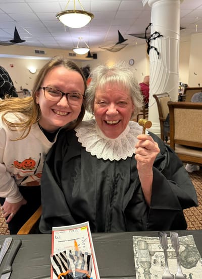 Resident and staff member celebrating an event with smiles