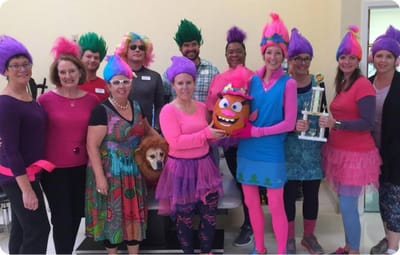 Staff dressed in colorful costumes at an event