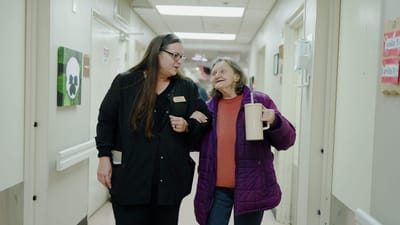 Staff assisting a resident in a hallway