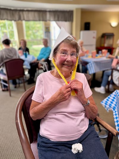 Resident participating in an activity with a hat and smiles