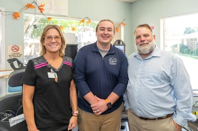Staff and administrator posing in an activity area