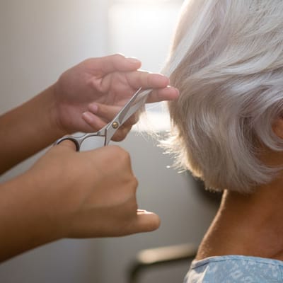 A resident receiving a haircut in a facility