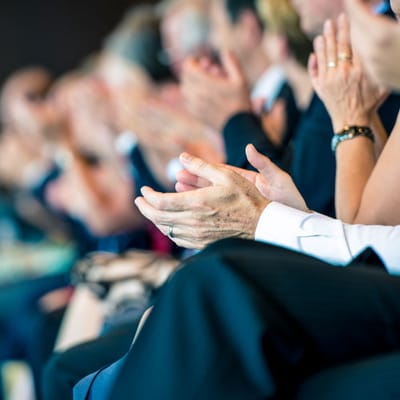 Audience members applauding at an event