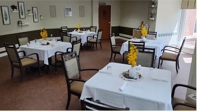 Bright dining room with neatly set tables and flowers