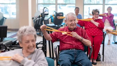 Residents participating in a group exercise class in a common area