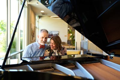 Residents enjoying music together at a grand piano