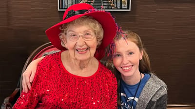 Senior resident with staff member in an activity room