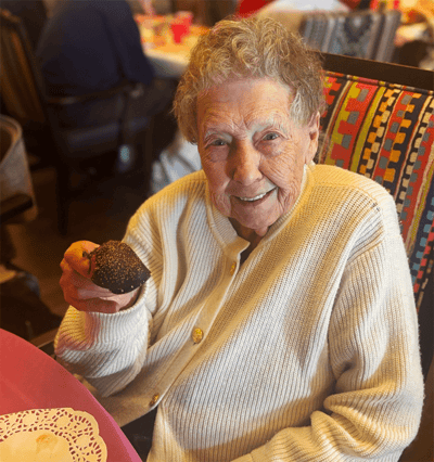 Resident smiling while holding a dessert