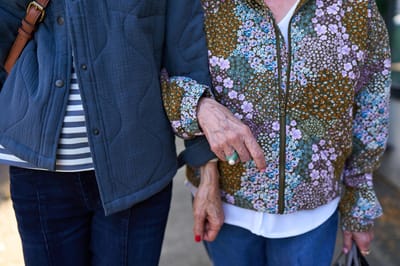 Two residents walking closely together outdoors