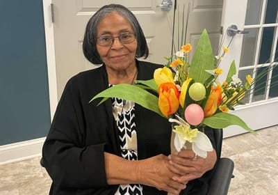 Resident holding a bouquet of flowers in common area