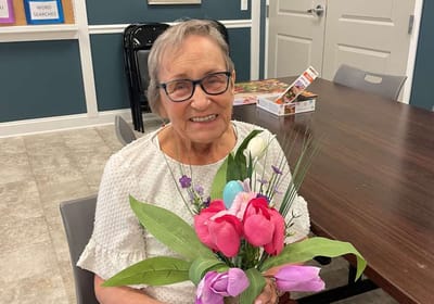 A resident holding a bouquet of flowers in a common area