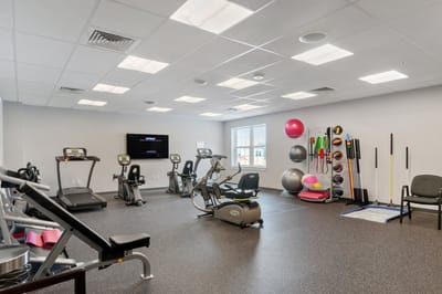 Fitness room with exercise equipment and mats