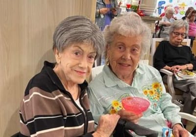 Two residents enjoying a colorful drink in a common area