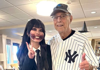 Resident posing with staff member in a themed outfit
