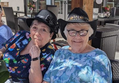 Two residents enjoying their time outdoors in stylish hats
