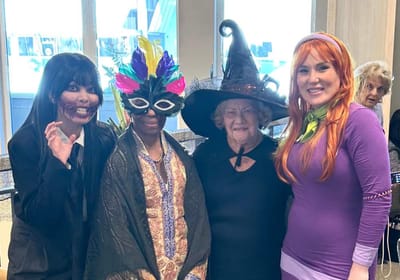 Residents and staff dressed in costumes at a Halloween celebration