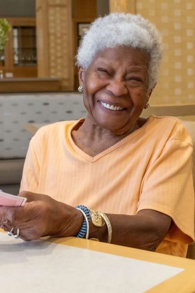 Smiling resident playing cards in a common area