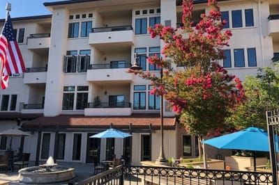 Exterior view of a senior living facility with flowering trees