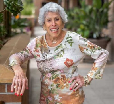 Senior woman smiling outside, dressed in floral attire