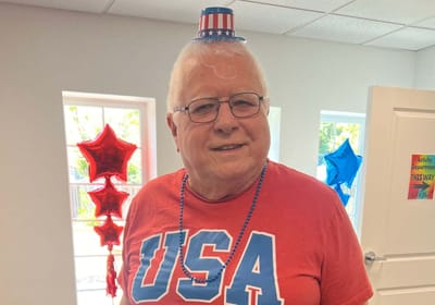 Resident celebrating with patriotic attire in activity room