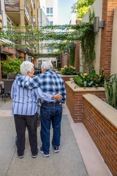 Two residents walking in a lush outdoor area