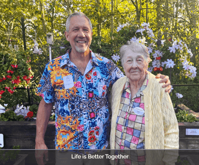 Caregiver and resident smiling in a garden
