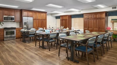 Bright, welcoming activity room with tables and chairs