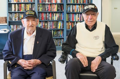 Two veterans in a common area of a memory care facility