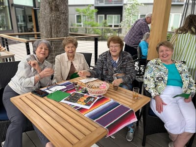 Four residents enjoying drinks on an outdoor patio