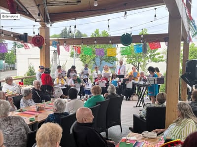 Residents enjoying a musical activity on an outdoor patio