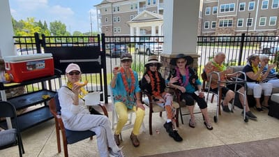 Residents enjoying a sunny outdoor gathering with drinks