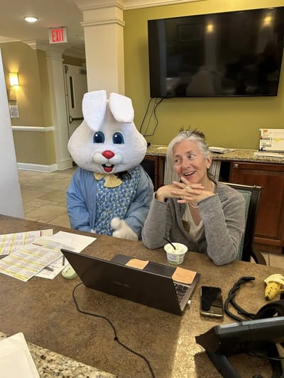 Staff member smiling with a person in a bunny costume