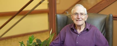 Senior resident smiling in a comfortable chair