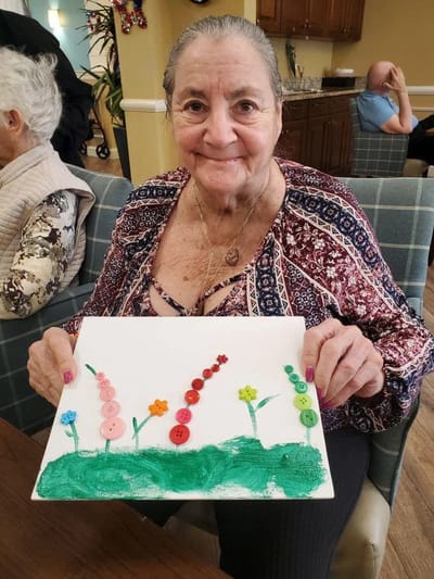 Resident showcasing an art project with buttons