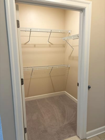 Empty closet with shelves in a neutral-colored room