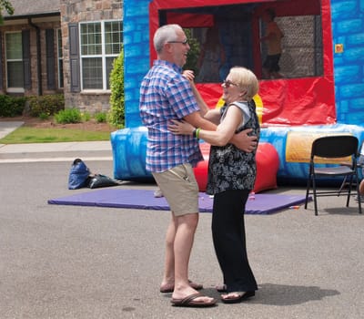Residents enjoying a dance outside near a bouncy castle