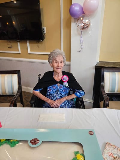 Resident celebrating with a birthday badge in a common area