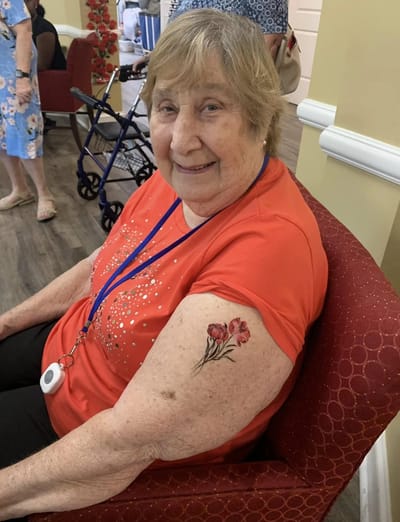Resident with temporary tattoo smiling in a common area