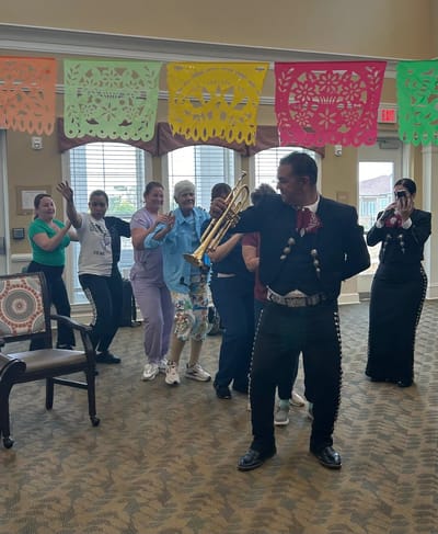 Residents and staff celebrating with music in a common area