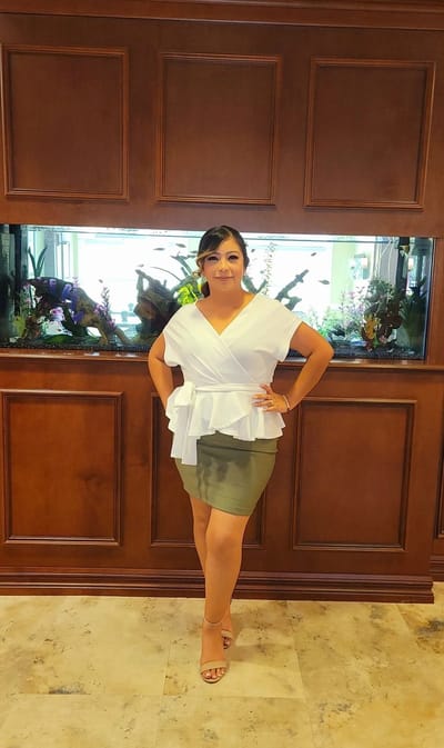 Staff member posing in front of an interior aquarium
