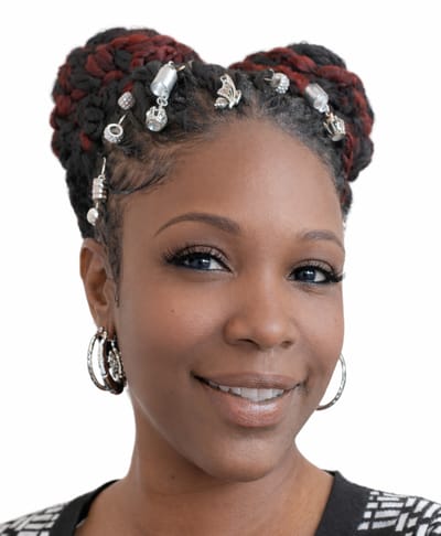 A woman with braided hair and decorations smiling