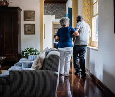 A caregiver assisting a resident in a hallway