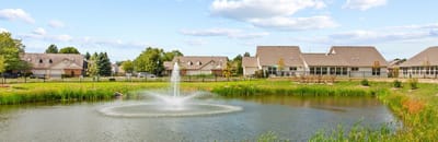 Scenic view of a pond with fountain and residential buildings
